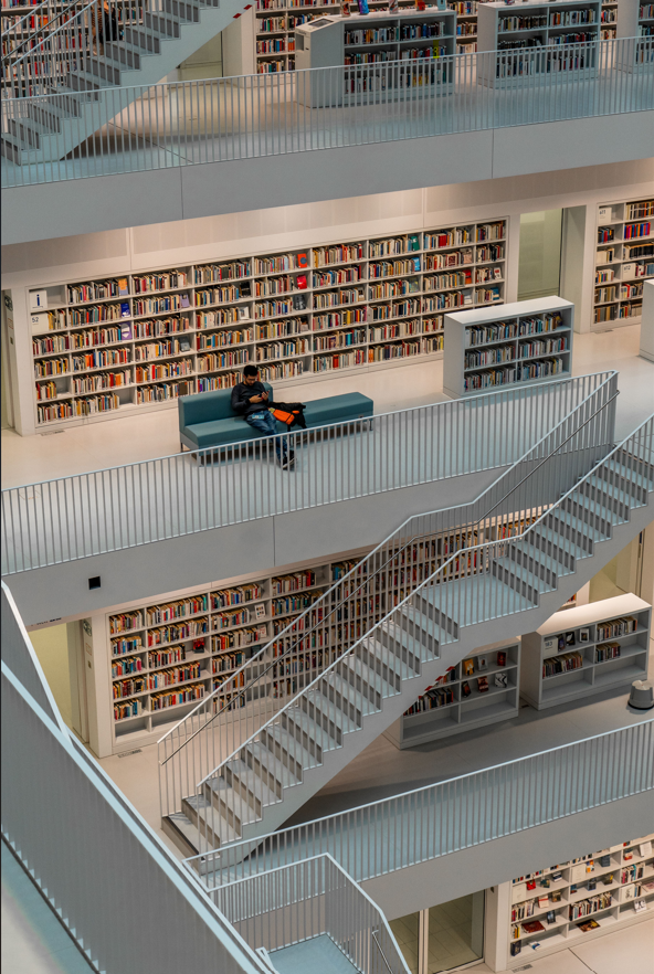 Bibliothèque sur plusieurs étages avec une personne en lecture